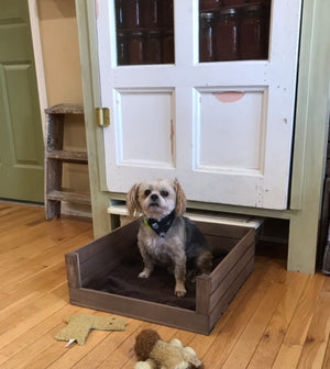 Handmade wooden dog bed with medium brown stain and cozy blanket