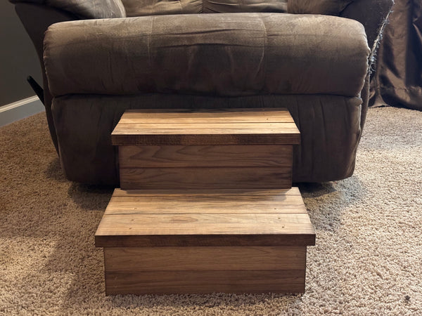 Straight-on view of 2-tier wooden pet stairs in Early American stain against a recliner.