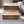Handcrafted Early American wooden pet stairs in front of modern sofa on light rug.